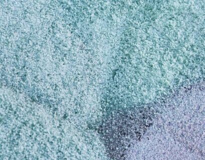 Manos sosteniendo gránulos de material reciclado empleado por URSA en la fabricación de poliestireno extruido XPS