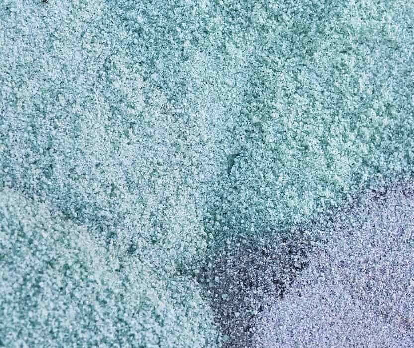Manos sosteniendo gránulos de material reciclado empleado por URSA en la fabricación de poliestireno extruido XPS